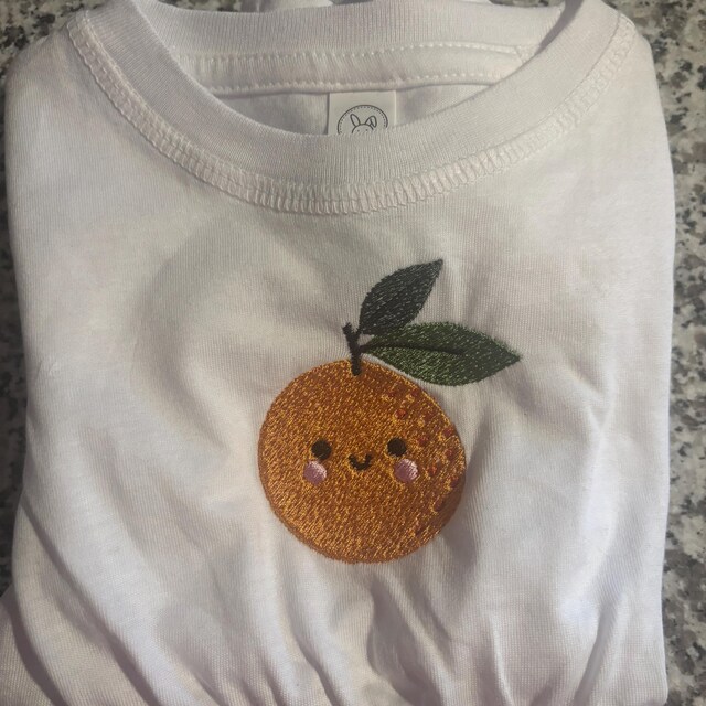 Customer’s Sunny Orange embroidery on a white shirt